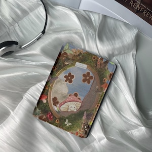 Könnte beinhalten: Nahaufnahme eines Buchumschlags mit einer farbenfrohen Illustration eines Pilzes mit einem Gesicht, Blumen und Schmetterlingen. Der Text auf dem Umschlag lautet "From the Garden".