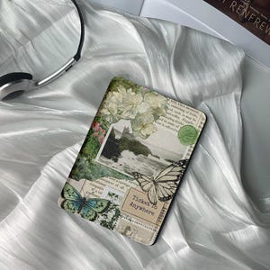 Puede incluir: Una cubierta de libro de estilo vintage con un collage de imágenes, incluyendo una mariposa, flores y un paisaje. El texto en la cubierta dice "Ticket to Anywhere".