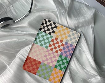 May include: An e-reader cover with a colourful checkered pattern and a black border. The cover is made from a soft, textured material and features a range of colours, including red, green, blue, yellow, and pink.