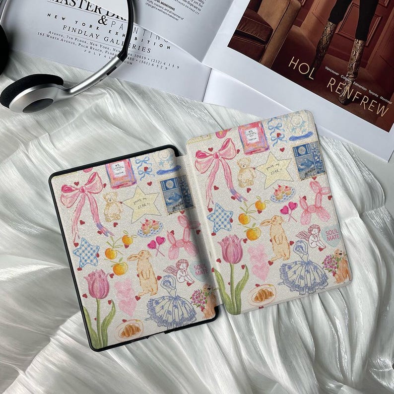 May include: A white and pink patterned e-reader cover with a variety of illustrations including hearts, stars, balloons, and a bunny rabbit. The cover has the text "Soul Mate" printed on it.