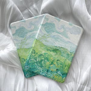 May include: A white ceramic mug with a black handle and the text "But First, Coffee" in a black, handwritten-style font. The mug is on a white surface.