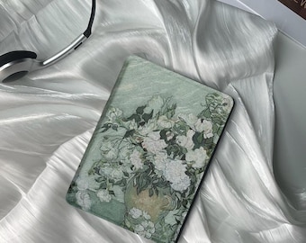 May include: A green and white floral print phone case with a vase of white flowers. The case is on a white fabric background.