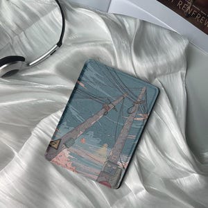May include: A blue and pink illustrated e-reader case with a design of power lines and a sunset sky.