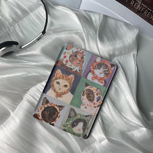May include: A colourful book cover featuring a collage of cats wearing flower crowns. Each cat is in a different pose and has a unique expression. The cover is made from a durable material and is ideal for protecting your book.