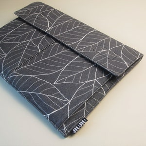 May include: A gray laptop sleeve with a white leaf pattern. The sleeve has a flap closure and a small label with the text "JIUJIU". The design features a repeating pattern of stylized leaves.