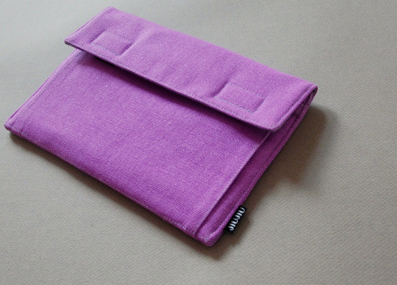 May include: A lilac fabric case with a flap closure. The case is rectangular with a textured surface. The flap features two stitched rectangular details. The brand name "JIJIU" is on a small black tag.