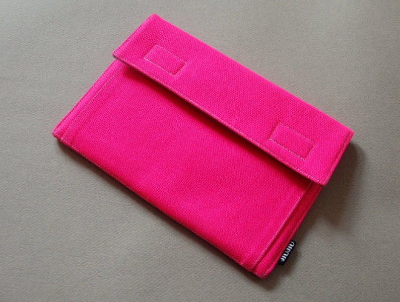 May include: A vibrant pink rectangular clutch bag with a flap closure. The bag is made of a textured fabric and has two rectangular accents on the flap. The brand name "jijiu" is printed on a small tag.