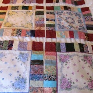 Pu&ograve; includere: Una trapunta realizzata con una variet&agrave; di tessuti, tra cui stampe floreali, strisce e colori solidi. La trapunta &egrave; composta da quadrati e rettangoli ed &egrave; cucita con filo bianco. La trapunta &egrave; stesa su un letto ed &egrave; pronta per essere trapuntata.