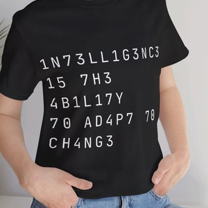 Puede incluir: Camiseta negra con texto blanco que dice "1N73LL1G3NC3 15 7H3 4B1L17Y 70 AD4P7 70 CH4NG3"