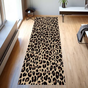 Puede incluir: Un tapete de corredor de color marrón y negro con estampado de leopardo. El tapete tiene un fondo beige con manchas negras.