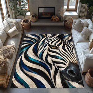Può includere: Un tappeto rettangolare che presenta un ritratto artistico di una testa di zebra su larga scala. Il design utilizza audaci strisce nere, bianche e blu intenso che scorrono sulla superficie, con un occhio color ambra visibile al centro.
