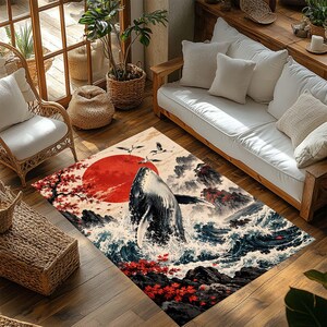 May include: A rectangular area rug featuring a detailed illustration of a whale breaching from ocean waves. The design includes a large red sun, dark rocky cliffs, and vibrant red maple leaves. The scene is rendered in a style reminiscent of traditional Japanese woodblock prints with deep blue, white, and red color tones.