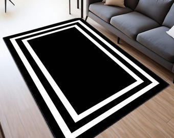 Pode incluir: Tapete preto e branco com uma dupla borda branca. O tapete tem um design geométrico moderno.