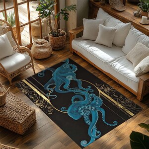May include: A rectangular black area rug featuring two stylized blue octopuses within a gold circular design. Gold stripes and floral accents border the rug. The rug is placed on a hardwood floor.