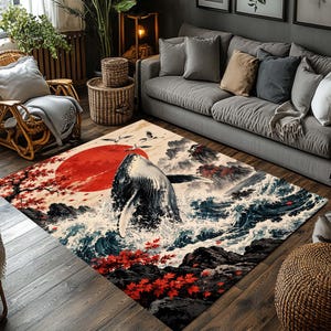 May include: A rectangular area rug featuring a detailed illustration of a whale breaching from dark blue ocean waves. The scene includes a large red sun, flying cranes, and vibrant red maple leaves against a backdrop of rocky cliffs and mountains.