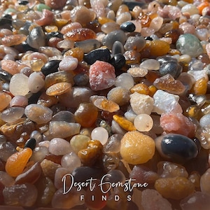 Puede incluir: Una colección de piedras de ágata de colores en varias formas y tamaños. Las piedras son lisas y pulidas, con una variedad de colores y patrones. Las piedras están dispuestas en un patrón aleatorio, creando una exhibición visualmente atractiva.