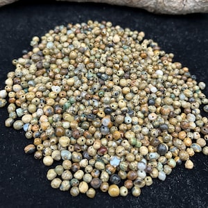 May include: A white ceramic mug with a black handle and the text "But First, Coffee" in a handwritten style. The mug is on a white surface. The mug is approximately 4 inches tall.