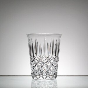 May include: A clear glass vase with a diamond pattern. The vase is empty and has a wide mouth.
