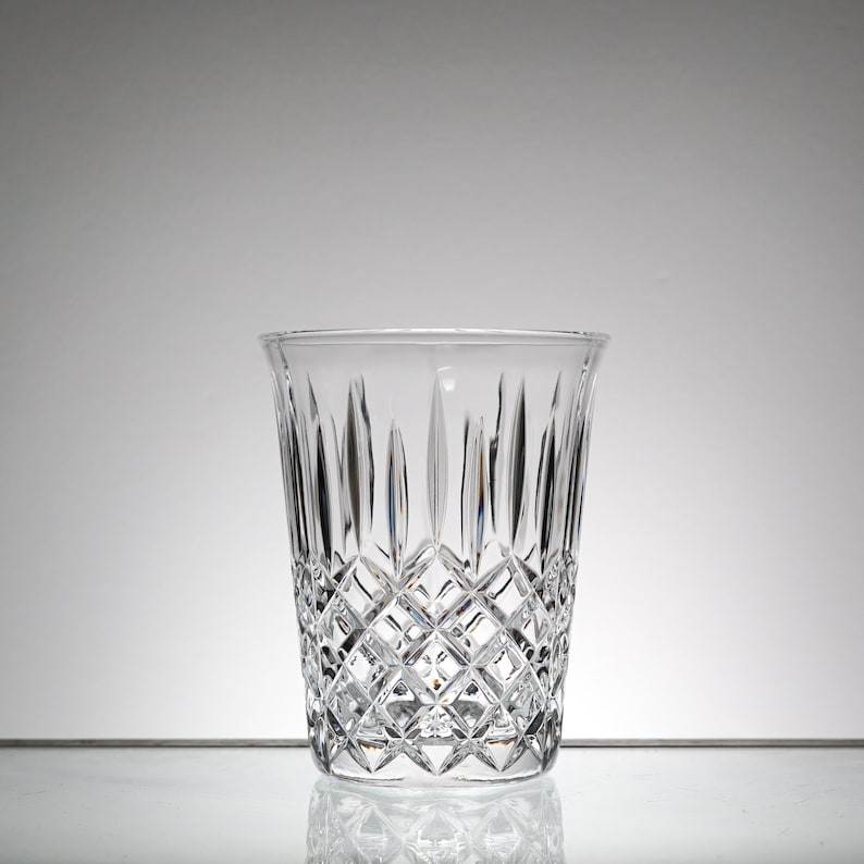 May include: A clear glass vase with a diamond pattern. The vase is empty and has a wide mouth.
