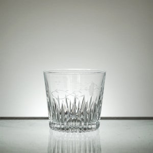 Puede incluir: Un vaso de vidrio transparente con un dise&ntilde;o de vidrio cortado y un patr&oacute;n floral grabado.