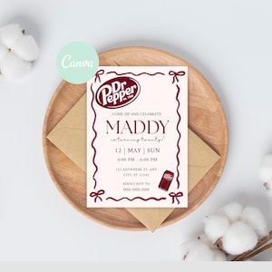 May include: A cream-colored invitation with burgundy accents, featuring the Dr. Pepper logo and text that reads "COME SIP AND CELEBRATE MADDY." The invitation includes date, time, and RSVP information. It is placed on a wooden plate with a brown envelope.