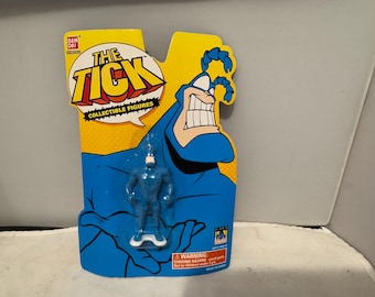 May include: A blue action figure of The Tick, packaged on a yellow and blue backing card. The card features the character's face and the words "The Tick Collectible Figures". The figure is a collectible item.