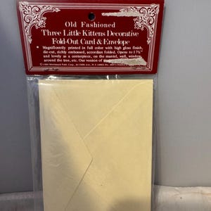 Peut inclure: Une carte et une enveloppe pliantes jaunes avec une bordure rouge et blanche. La carte pr&eacute;sente un motif de trois chatons. Le texte sur le devant indique "Old Fashioned Three Little Kittens Decorative Fold-Out Card & Envelope".