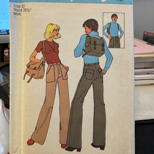 May include: Simplicity sewing pattern number 1164 for a women's pants and top pattern. The pattern is for sizes 12 with a 26 1/2 inch waist. The pattern shows two models wearing the pants and top. The woman is wearing brown pants and a red top. The man is wearing green pants and a blue top. The pattern is $1.50.