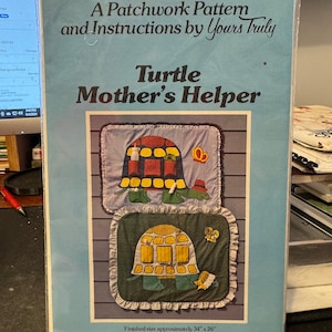 May include: A patchwork pattern and instructions for a turtle-themed quilt. The pattern is titled "Turtle Mother's Helper" and shows two turtle designs, one with a baby turtle and the other with a crown. The finished size is approximately 34 inches by 26 inches.