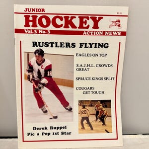May include: A vintage "Junior Hockey Action News" magazine cover. The cover features a hockey player in a red and white uniform, and the headline "Rustlers Flying." Other text includes "Eagles on Top" and "Derek Ruppel Pic a Pop 1st Star."