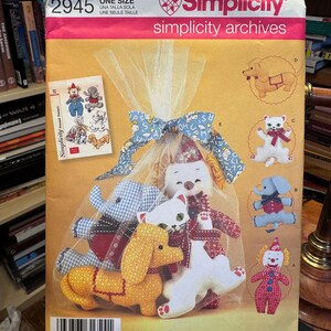 Op de afbeelding: Simplicity naaipatroon voor het maken van knuffels, waaronder een hond, kat, olifant en clown. Het patroon is gelabeld met "2945" en bevat de tekst "Simplicity Archives".