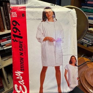 Könnte beinhalten: Ein McCall's Schnittmusterumschlag für ein weißes Hemdkleid, beschriftet mit 7035 Größe B. Die Vorderseite zeigt einen roten vertikalen Streifen mit dem Text Easy Stitch 'n Save und $1.99. Es zeigt zwei Bilder eines weißen Hemdkleides mit kurzen Ärmeln.