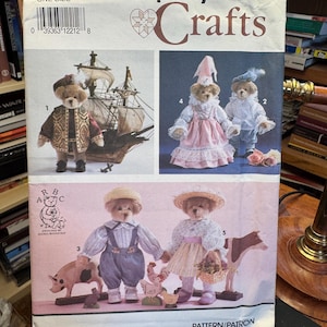 Puede incluir: Patrón de costura Simplicity Crafts con osos de peluche con varios atuendos. El patrón incluye imágenes de osos vestidos de pirata, con un vestido rosa y con peto. Diseñado por Alexia Roosevelt.