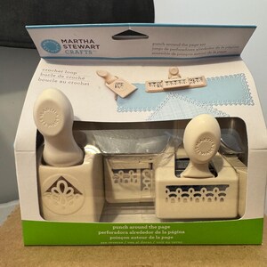 May include: A Martha Stewart Crafts punch around the page set in a box. The set includes two cream-colored punches with decorative designs, and a crochet loop punch. The box has text in English, Spanish, and French.