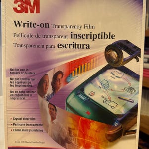 May include: A package of 3M Write-on Transparency Film. The package is white with blue and red accents. The package says "Not for use in copiers or printers". The package also says "Cont. 100 Sheets/Feuilles/Hojas". The package is 8.5 inches by 11 inches.