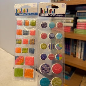 Puede incluir: Dos paquetes de pegatinas Color Oasis thoughts. Un paquete presenta pegatinas cuadradas con frases como "Over the rainbow" y "Crazy for You!". El otro paquete tiene pegatinas redondas con palabras como "believe" y "I love you!"
