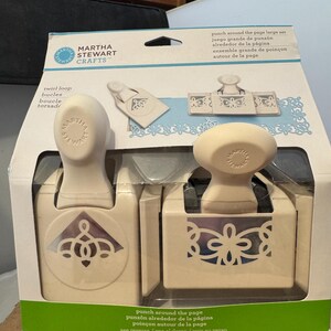 May include: A Martha Stewart Crafts punch around the page large set. The set includes two cream-colored punches with decorative cut-out designs. The packaging features the product name and instructions in multiple languages.