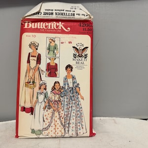 May include: A vintage Butterick sewing pattern packet, featuring illustrations of historical women's dresses. The red packet displays the number 4260, the text "MAKE IT REAL", and the year 1776. The packet includes multiple dress designs.