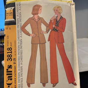 Könnte beinhalten: Ein Vintage-Schnittmuster von McCall's für eine Hemdbluse und eine Hose. Das Schnittmuster ist für Damen in den Größen 14 und 36. Das Schnittmuster ist ein Original von Halston und enthält Schritt-für-Schritt-Anleitungen. Das Schnittmuster stammt aus den 1970er Jahren und hat einen Retro-Stil.