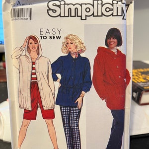 May include: Simplicity sewing pattern number 7015 for a hooded jacket. The pattern includes three different styles: a white jacket with red shorts, a blue jacket with plaid pants, and a red jacket with blue jeans. The pattern is labeled "Easy to Sew".
