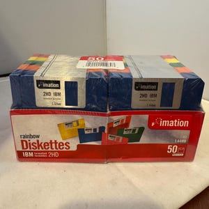May include: A box of 50 rainbow coloured 2HD IBM formatted diskettes from the brand "imation" with a capacity of 1.44MB. The box is red with a white label and features a picture of several diskettes.
