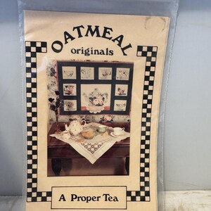 May include: A quilting pattern titled "A Proper Tea" by Oatmeal Originals. The pattern features a teacup and teapot design with floral accents.