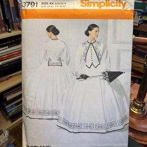 Peut inclure: Patron de couture Simplicity #3791, présentant une robe blanche ornée de noir et une veste assortie. Tailles disponibles : 8, 10, 12, 14, ainsi que les tailles EUR 34-40 et FR 36-42.