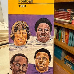 Puede incluir: Un folleto morado y blanco con el título "Husky Football 1981". La portada presenta a cuatro jugadores de fútbol con sus nombres debajo de sus retratos: Fletcher Jenkins, Mark Jerue, Vince Coby y James Carter.