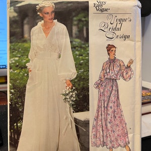 May include: A vintage Vogue's Bridal Design sewing pattern for a wedding dress. The pattern is for a long, white gown with a V-neck and long sleeves. The pattern number is 2053. Very Easy Vogue.