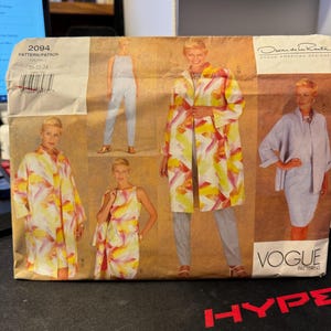 May include: A sewing pattern envelope for a women's coat, jumpsuit, and top. The pattern is by Oscar de la Renta and is for sizes 20-22-24. The envelope is brown and has a picture of the garments on it.