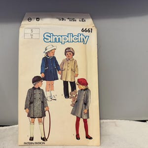May include: Vintage Simplicity sewing pattern envelope featuring illustrations of children's coats. The envelope is cream-colored with the Simplicity logo and pattern number 6661. The children are wearing coats in various colors, including blue, tan, and gray.