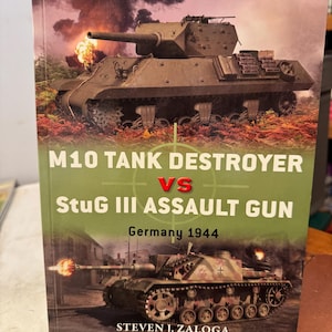 May include: A book titled M10 Tank Destroyer vs StuG III Assault Gun Germany 1944 by Steven J. Zaloga. The cover features a dark green M10 tank destroyer above a camouflage StuG III assault gun firing its cannon, set against a smoky battlefield.