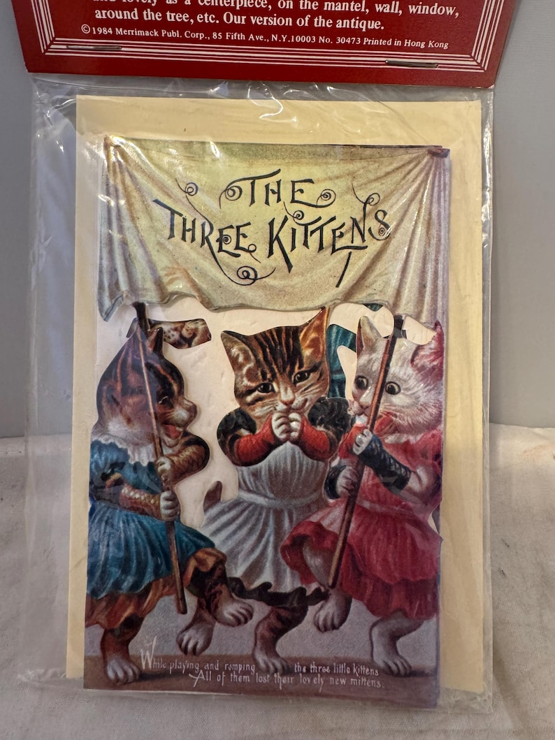 Peut inclure: Illustration vintage de trois chatons portant des robes et tenant des b&acirc;tons. Les chatons marchent et le texte "THE THREE KITTENS" est au-dessus d'eux. Le texte sous les chatons dit "While playing and romping the three little kittens All of them lost their lovely new mittens."