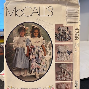 May include: A sewing pattern for a girl's dress. The pattern is from McCall's and is designed by Kitty Benton. The pattern is for size 8 and includes instructions for making a dress with a ruffled skirt and a lace trim.